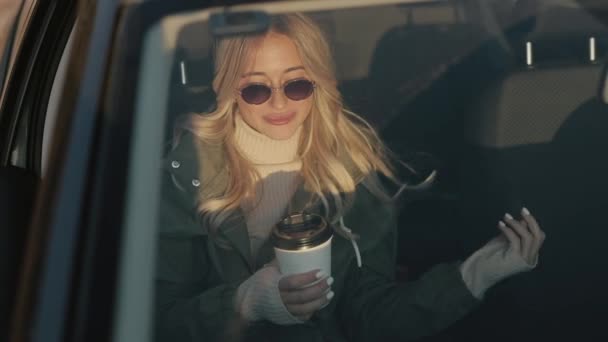 Mujer bebiendo té caliente en un coche — Vídeo de stock