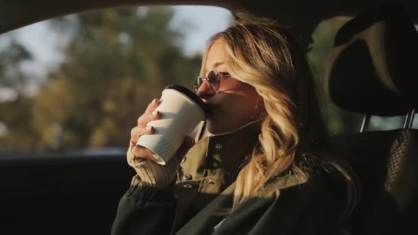 Mujer bebiendo té caliente en un coche — Vídeos de Stock