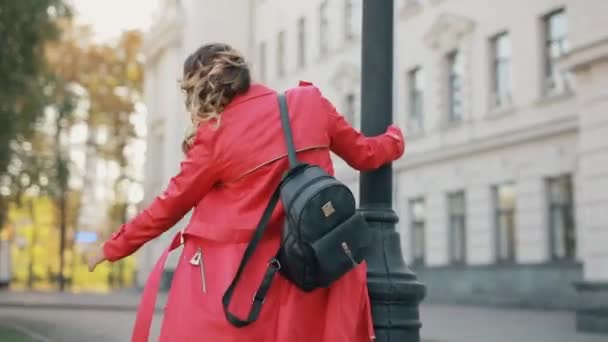 Mujer caminando por el callejón disfruta del día de otoño — Vídeos de Stock