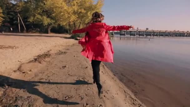 Жінка насолоджується осіннім днем біжить на річковому узбережжі — стокове відео