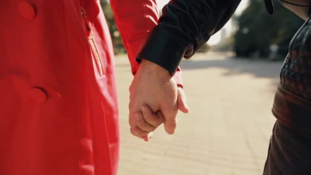 Nierozpoznawalne pary chodzenie trzymając ręce w alei miejskiej — Wideo stockowe