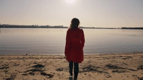 Samotna kobieta iść do rzeki, widok z powrotem — Wideo stockowe