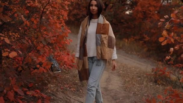 Kobieta ciesząca się jesiennym dniem, spaceruje w lesie, kolorowe liście wokół, zwolnione tempo — Wideo stockowe