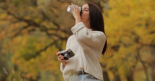 Woman photographer take a photo walking in the autumn forest — Stock Video