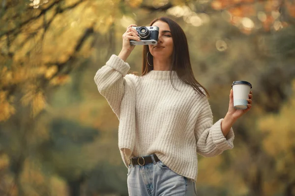Mulher fotógrafa tirar uma foto andando na floresta de outono — Fotografia de Stock