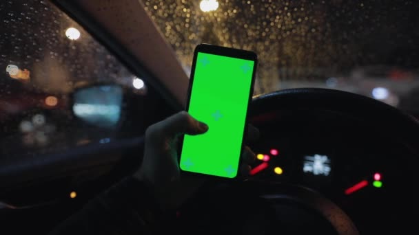 POV, mão masculina segurando smartphone com tela verde em um carro à noite — Vídeo de Stock