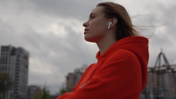 Mujer escuchando música en el día frío, estado de ánimo, nublado — Vídeos de Stock