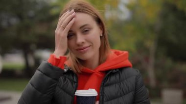 Güzel bir kadının portresi kameraya bakıp saçlarına dokunuyor.