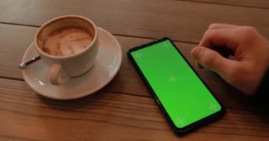 Bir erkeğin elinde boş yeşil akıllı telefon ekranı kullanmak.