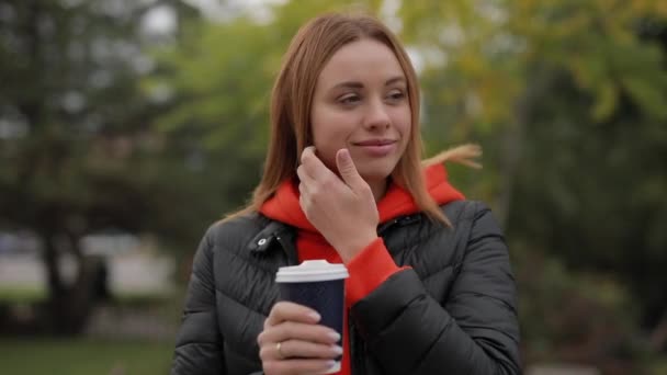Retrato individual de una hermosa mujer mirando a la cámara sosteniendo una taza de café — Vídeos de Stock