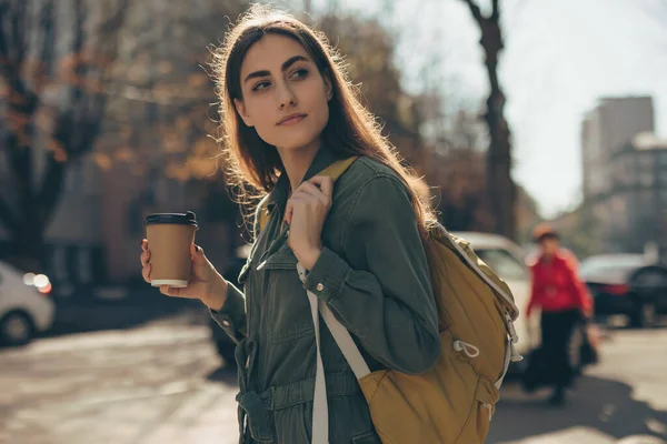 Mulher bonita segurando xícara de café de papel e desfrutar de caminhada na cidade — Fotografia de Stock