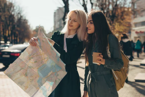 Mujeres amigos turistas explorando la ciudad mientras sostiene el mapa —  Fotos de Stock