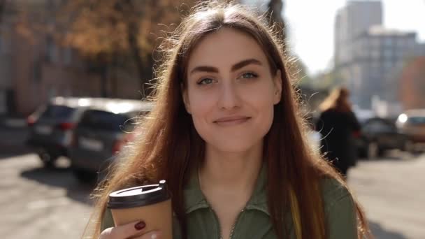 Mooie lachende vrouw met koffiekop in de stad — Stockvideo