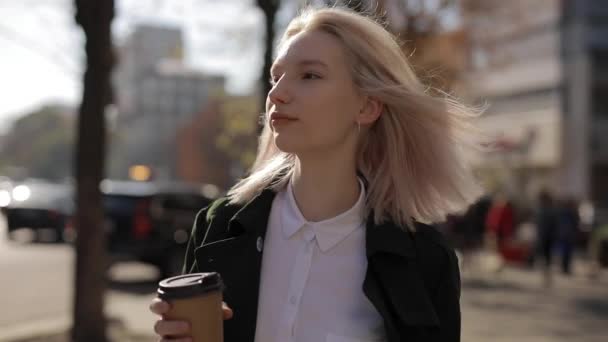 Söt blond kvinna dricka kaffe promenader i staden — Stockvideo