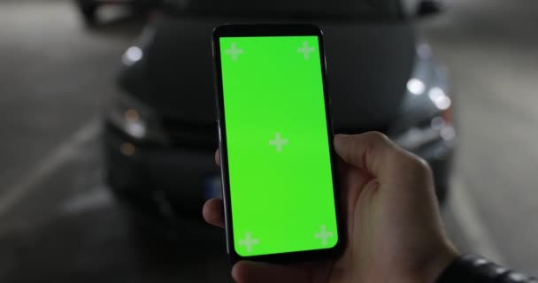 Макет мужской руки с зеленым экраном смартфона, подключенного к автомобилю, включил сигнализацию — стоковое видео