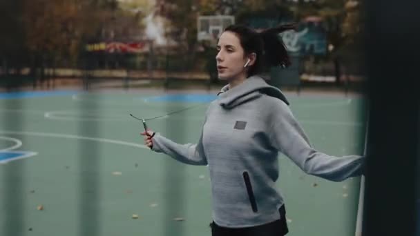 Спортивная женщина прыгает с веревки на стадионе — стоковое видео