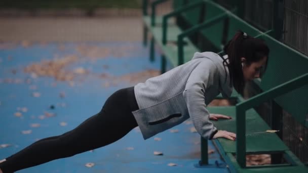 UCRANIA, DNEPR - 25 de octubre de 2019: Sport woman training outdoor makes push-ups — Vídeo de stock