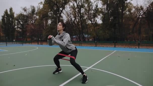 Mulher treinando ao ar livre com banda de força de resistência, goma de fitness — Vídeo de Stock