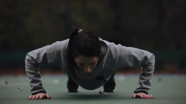 Женщина тренируется на открытом воздухе делает отжимания — стоковое видео
