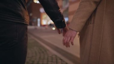 Çiftler el ele tutuşup gece kentinde yürüyüp gittiler.