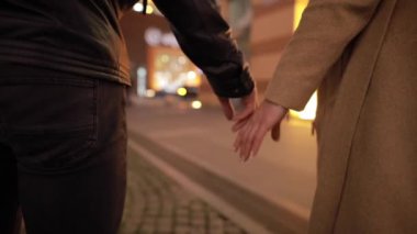 Çiftler el ele tutuşup gece kentinde yürüyüp gittiler.