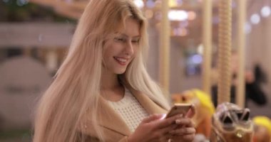 Kadın bir gece şehrinde çevrimiçi mesaj yazıyor