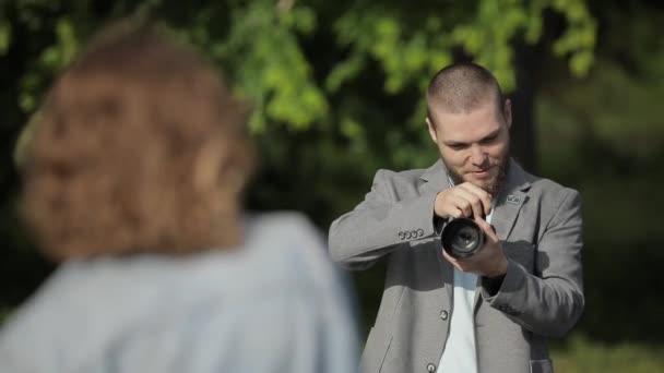 Fotógrafo hacer sesión de fotos para el modelo al aire libre — Vídeo de stock