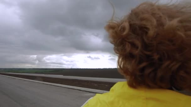 黄色のジャケットの女性は曇りの日に雲を見て — ストック動画