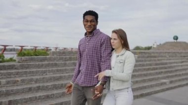 Mutlu çok ırklı arkadaşlar şehirde yürürken konuşurlar.