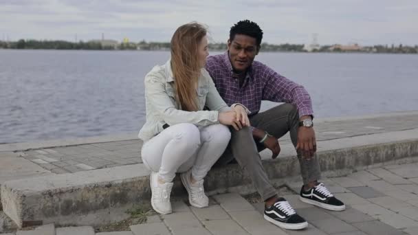 Multiraciala vänner samtalar sittande på vallen — Stockvideo