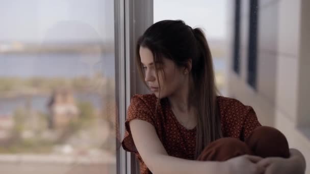 Sad woman looking through window — Stock Video