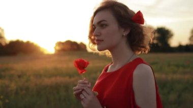 Haşhaş tarlasında kırmızı çiçekli kadın portresi