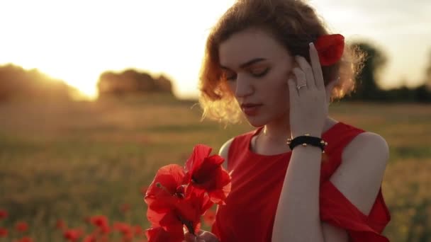 Retrato de mujer con flores rojas en un campo de amapola — Vídeo de stock