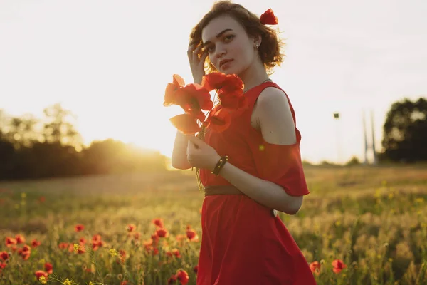 Portrait of woman with flowers in a poppy field — Stock Photo, Image