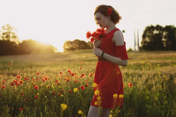 Portrait of woman with flowers in a poppy field — Stock Photo, Image