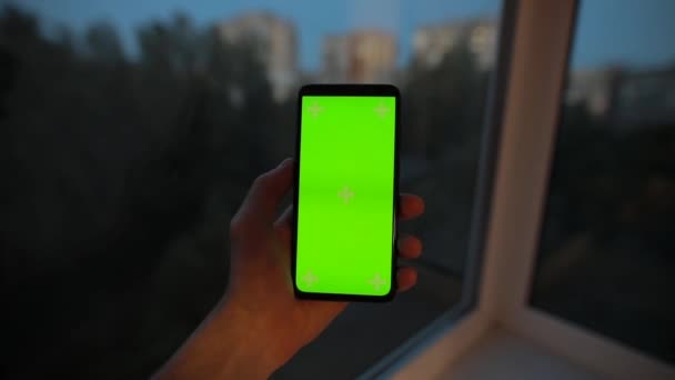 Menggunakan layar hijau kosong dari smartphone di balkon malam — Stok Video