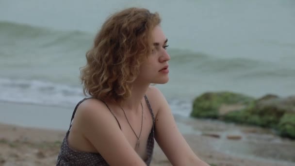 Hermosa mujer sentada cerca de la playa — Vídeos de Stock