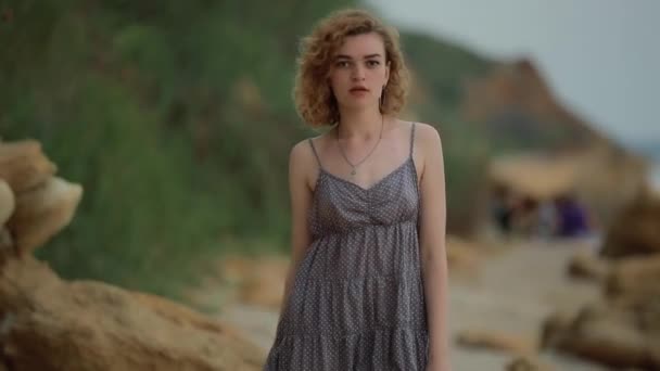 Модная женщина в платье, гуляющая по морскому пляжу — стоковое видео