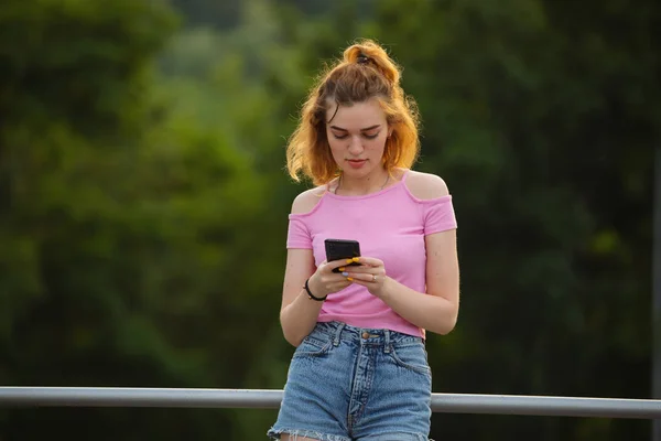 Mulher usando telefone celular no parque — Fotografia de Stock