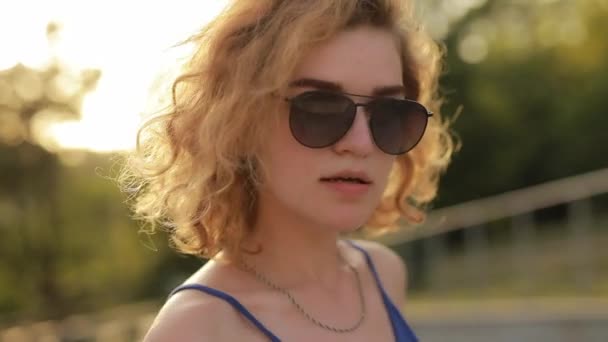 Νεαρή γυναίκα διασκεδάζει φορώντας γυαλιά ηλίου — Αρχείο Βίντεο
