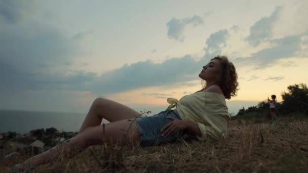 Nő fekszik a tetején, közel a tengerhez — Stock videók