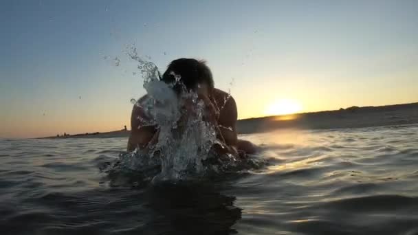 Hombre lavando la cara en el mar salpica agua, cámara lenta — Vídeo de stock