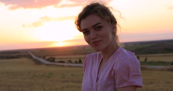 Hermosa mujer posando en un campo al atardecer — Vídeo de stock