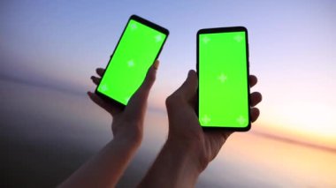 POV erkek ve kadın elleri boş ekranlı akıllı telefonları tutuyor