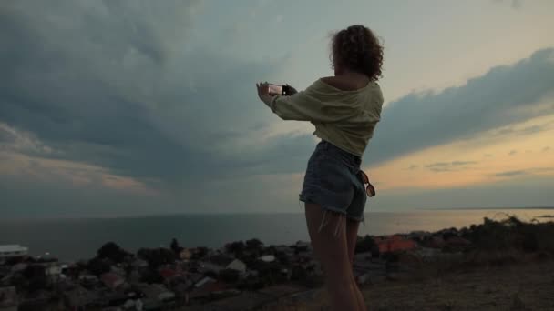 Женщина делает мобильное фото морского неба — стоковое видео