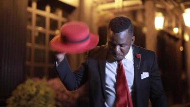 Afrikalı işadamı gece yarısı şapkasıyla dans ediyor.