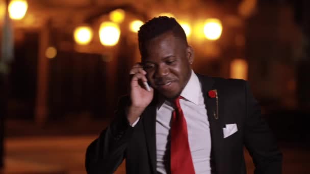 Afrikanske mænd kalder sin ven via smartphone og taler i natten byen – Stock-video
