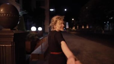 Güzel, seksi bir kadın benimle bir gece caddesinde el ele yürüyor.