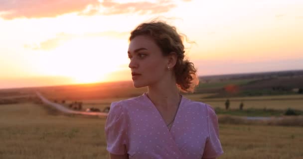 Красива жінка позує в полі на заході сонця — стокове відео