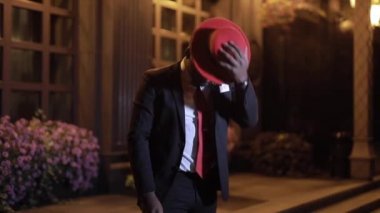 Afrikalı işadamı gece kentinde kırmızı şapka giydi.